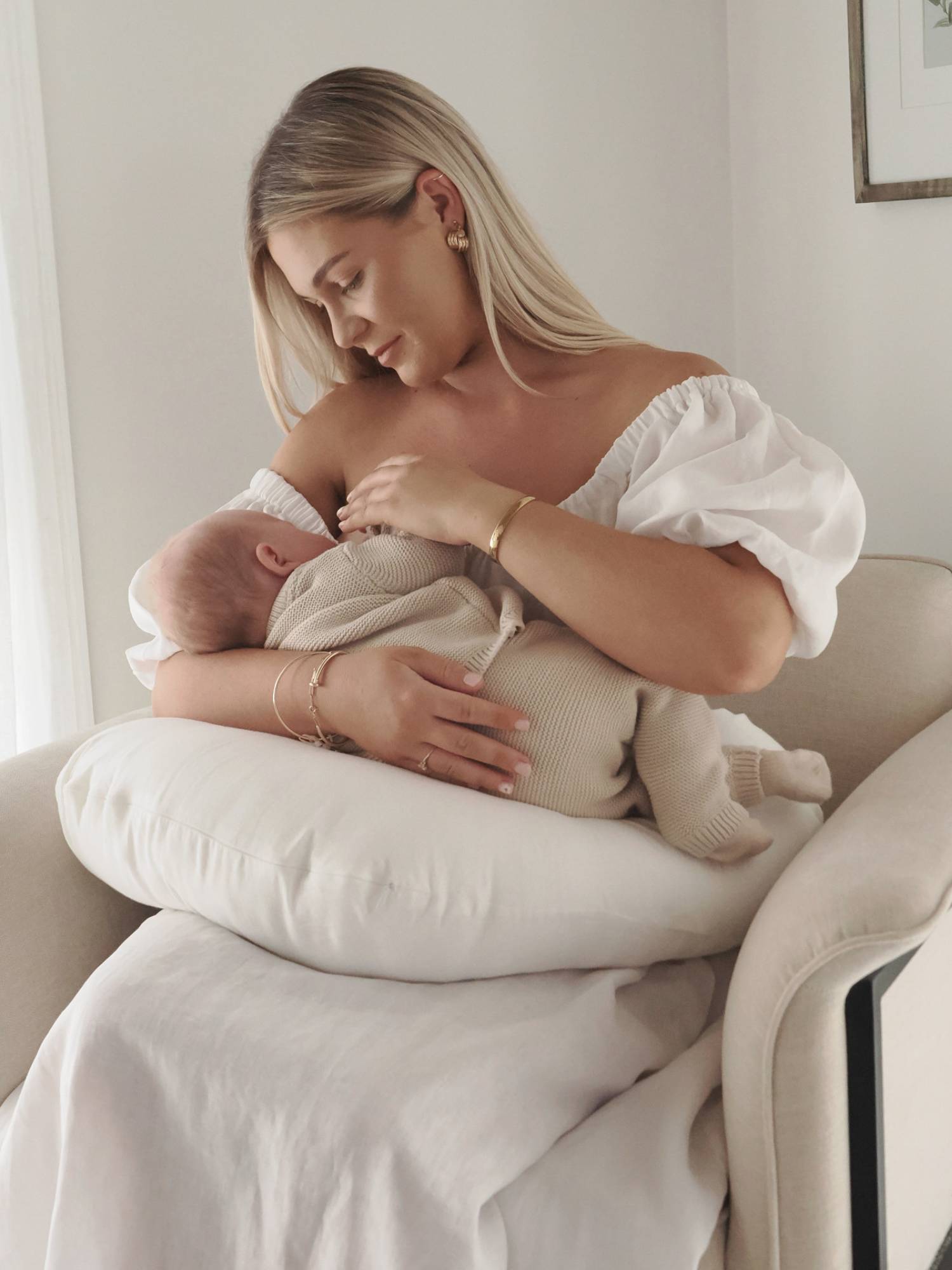 Woman breastfeeding a baby using a nursing pillow