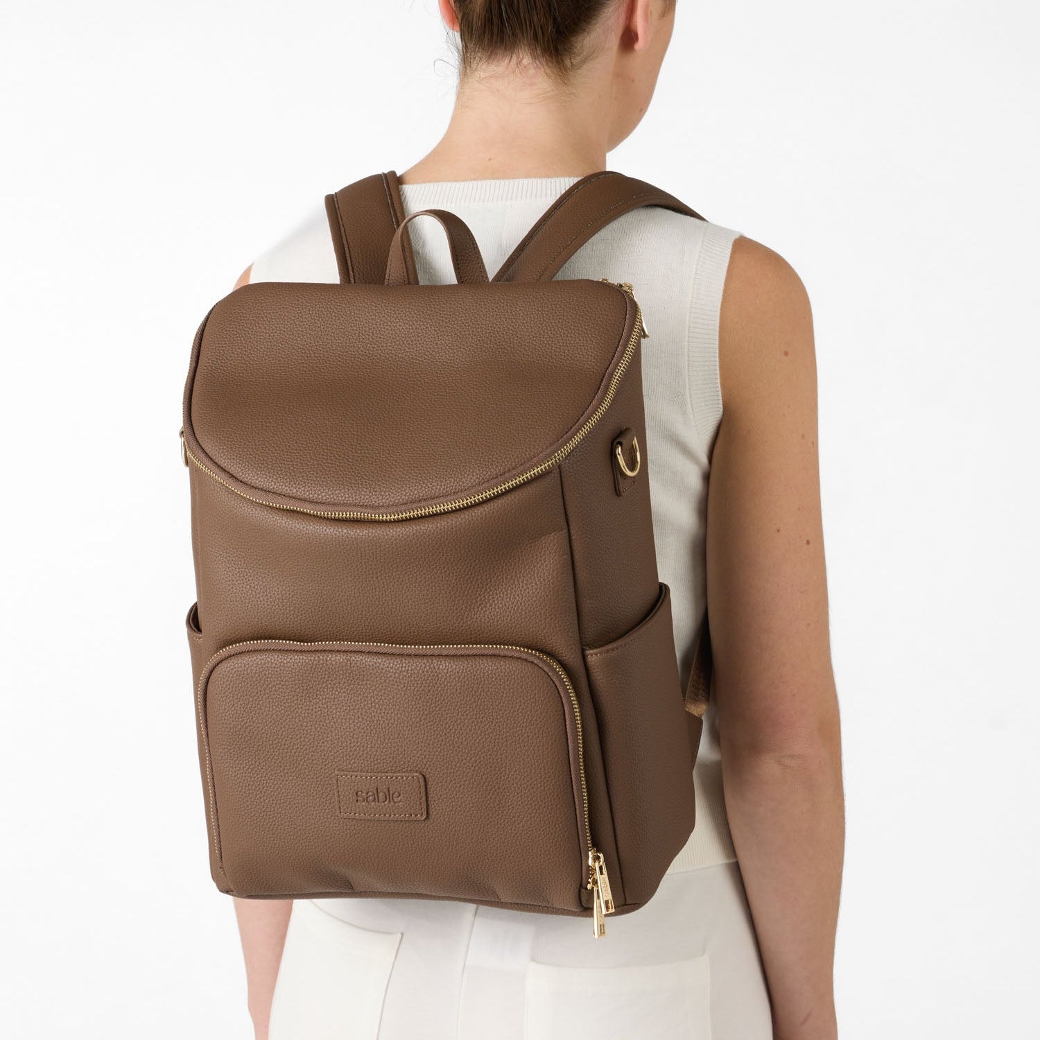 Brown nappy backpack for parents featuring adjustable shoulder straps and organised storage