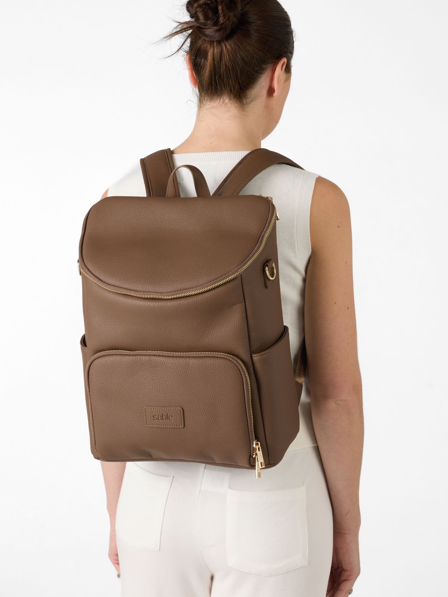 Brown nappy backpack for parents featuring adjustable shoulder straps and organised storage