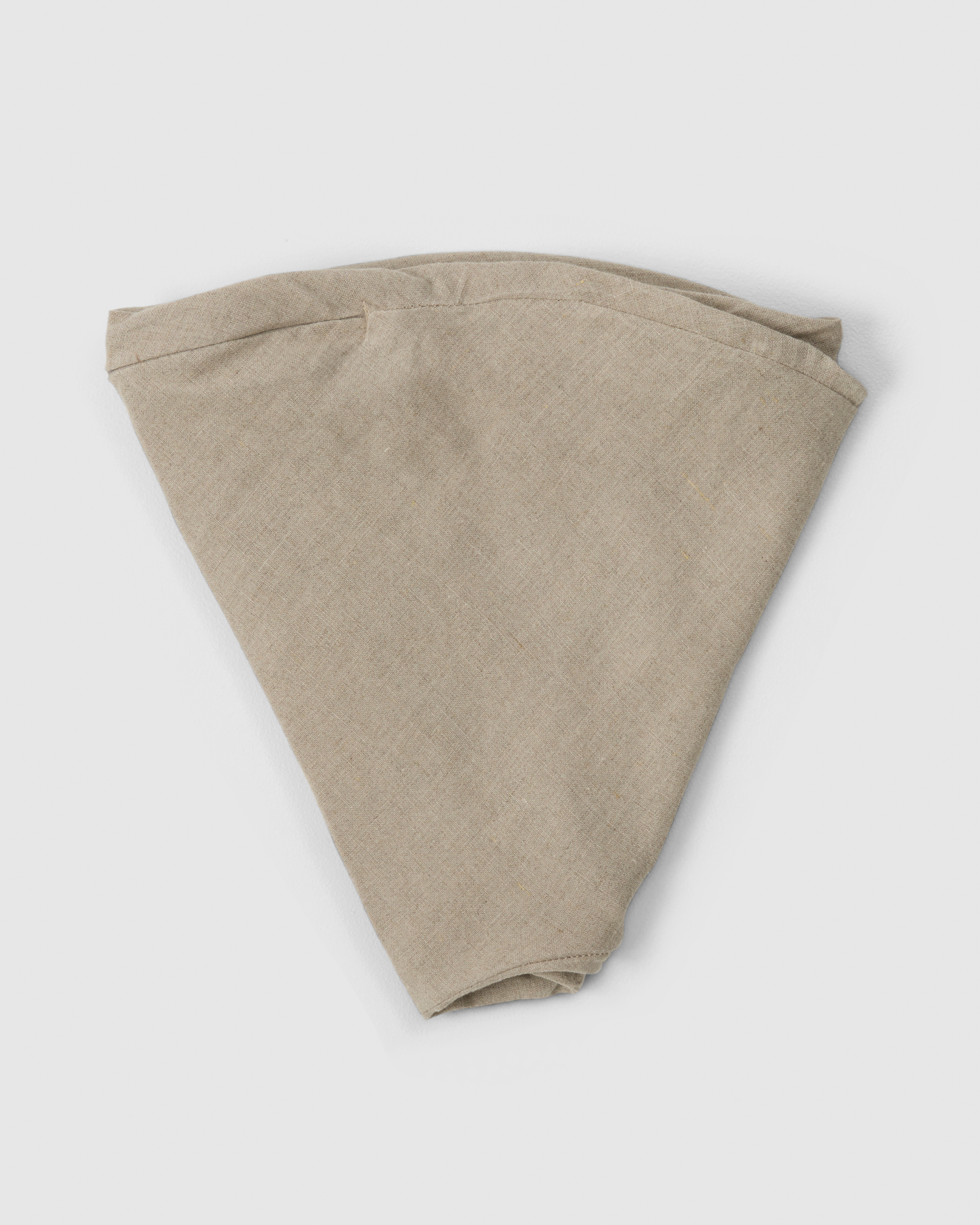 Folded linen nursing pillow cover in soft natural
