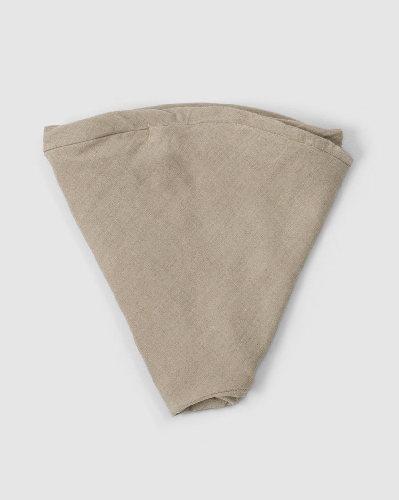 Folded linen nursing pillow cover in soft natural