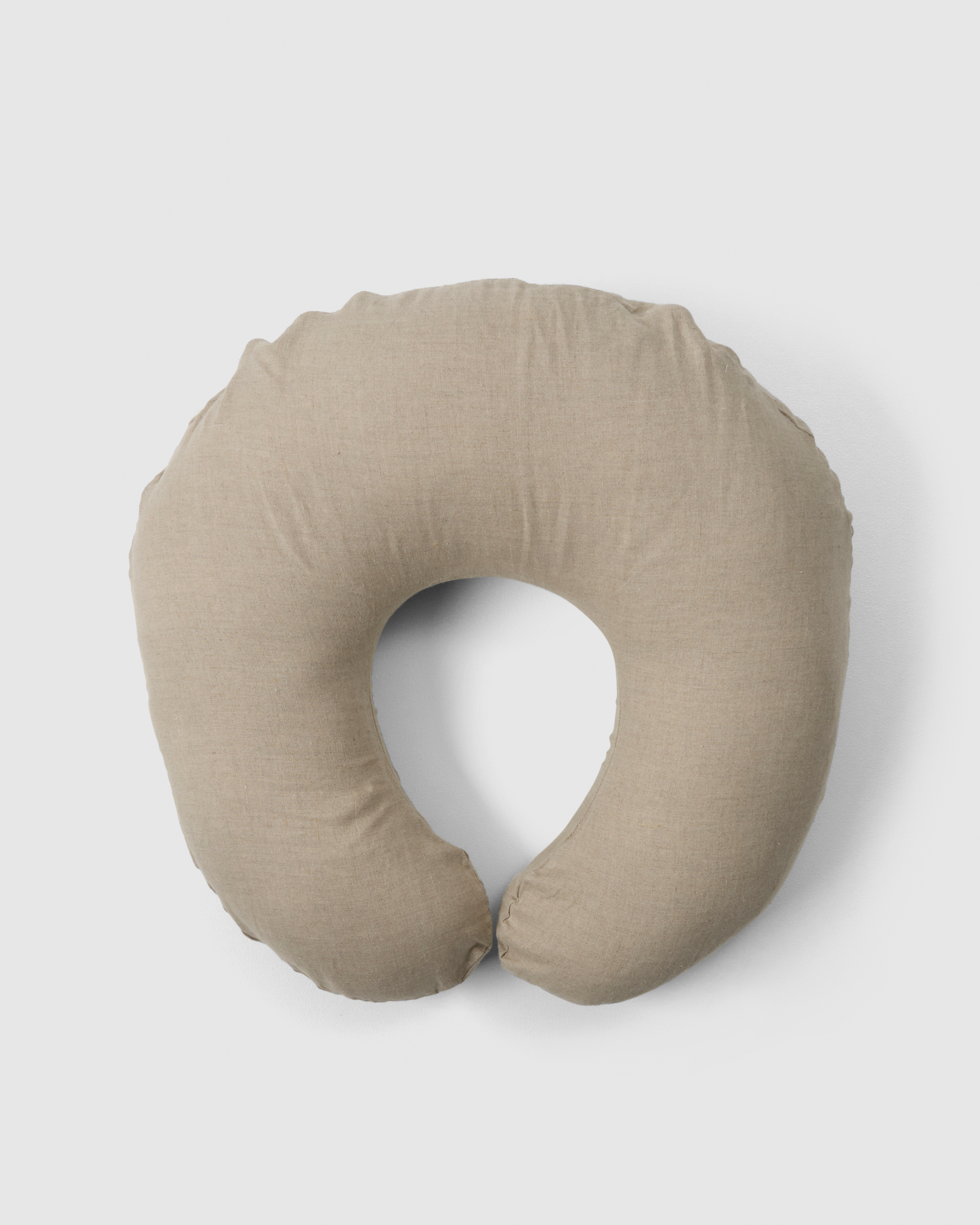 C-shaped nursing pillow providing support during feeding.