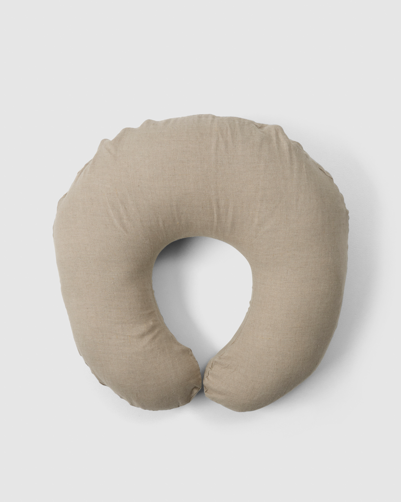 C-shaped nursing pillow providing support during feeding.