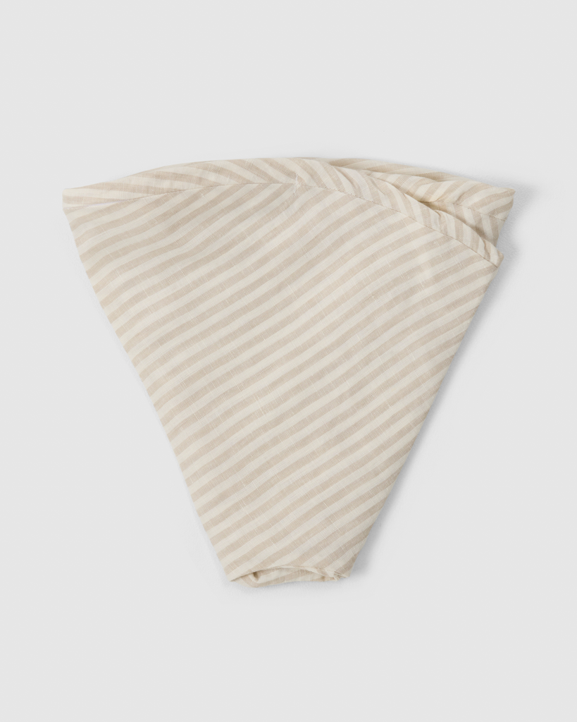 Folded linen nursing pillow cover in natural striped