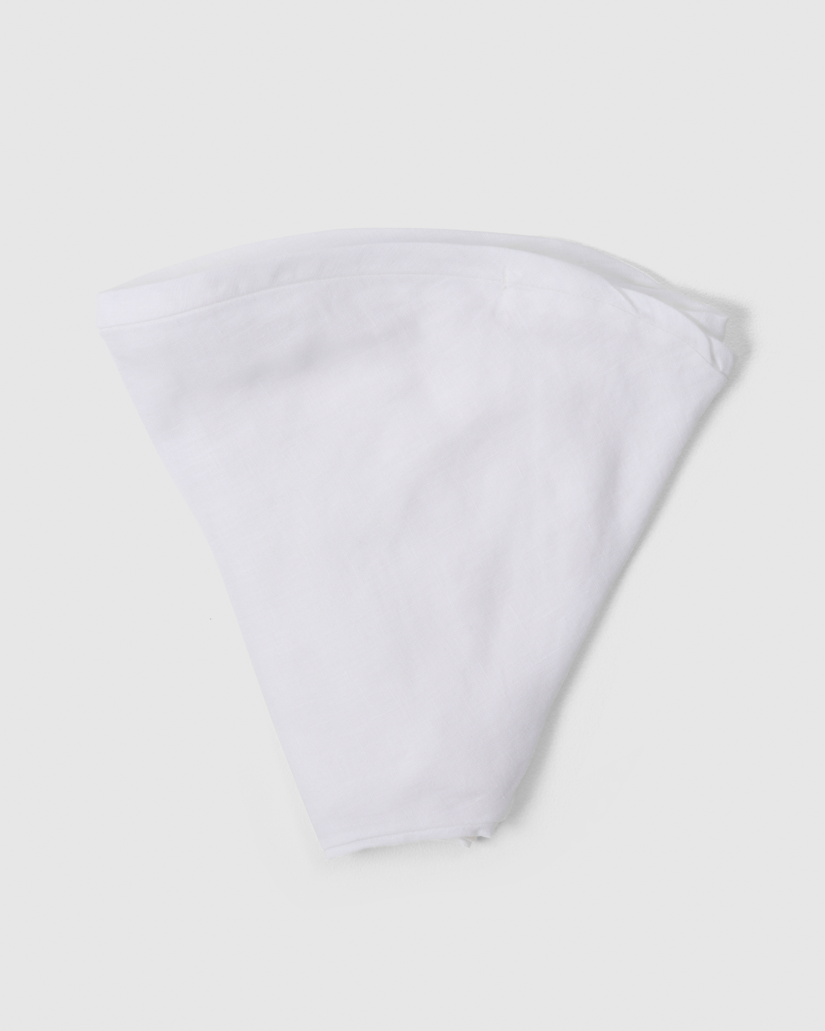 Folded linen nursing pillow cover in white