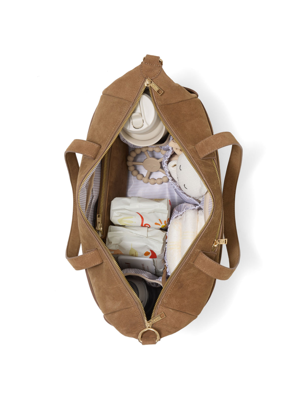 A brown suede-like nappy bag shown open from above, filled with folded baby items including a white bottle, a pacifier clip, and soft blankets, on a clean white background - Sable Bebe