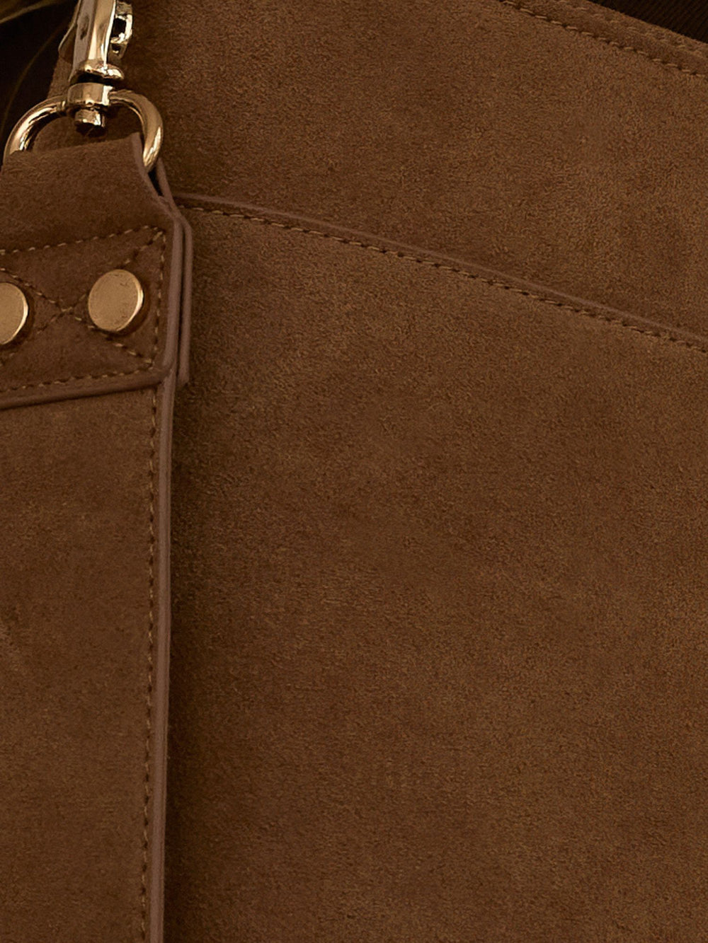 Close-up of brown suede texture with gold rivets on the strap