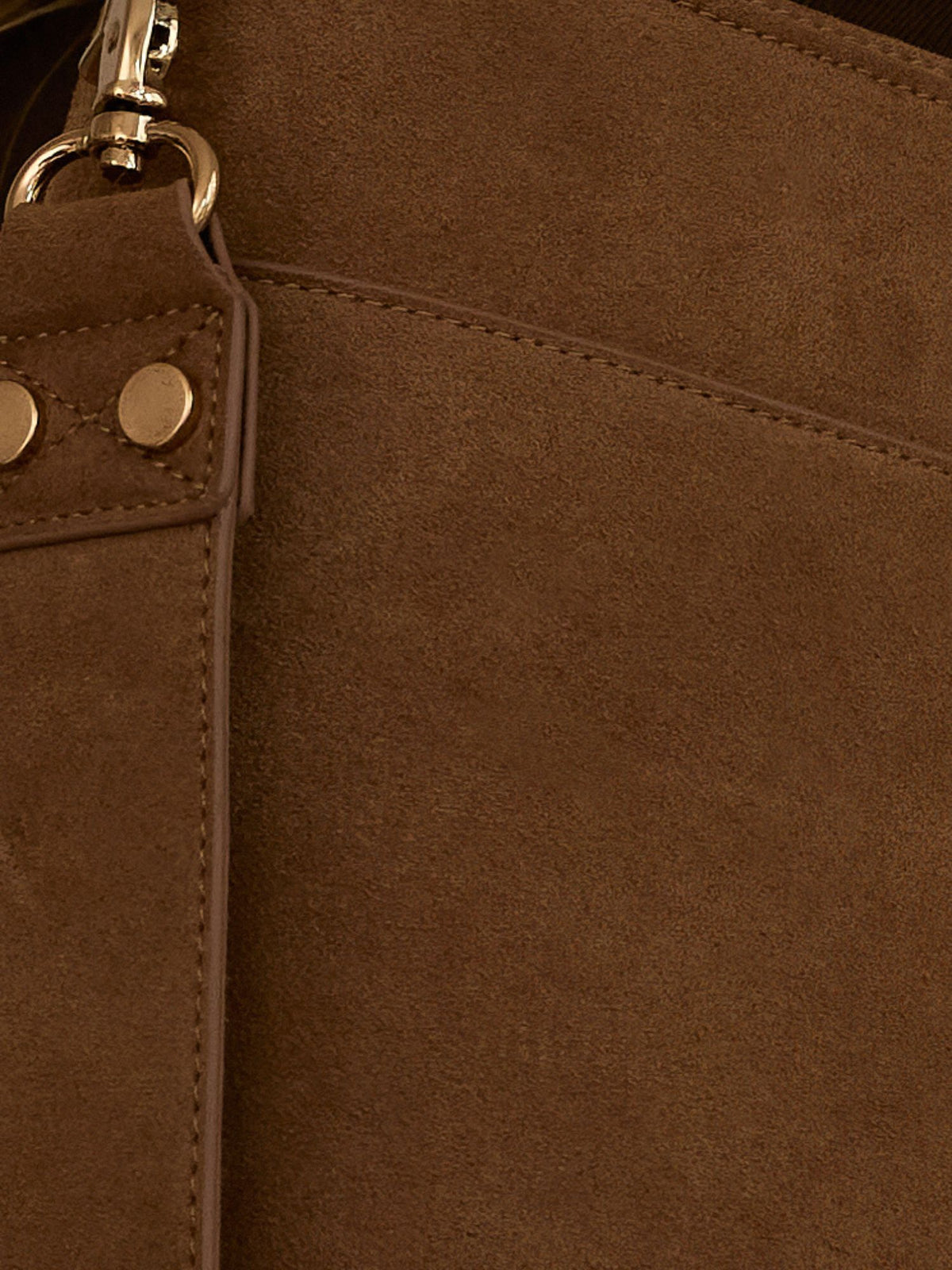 Close-up of a brown suede or faux-suede bag surface with a matching strap, gold-tone rivets, and a metal clasp.